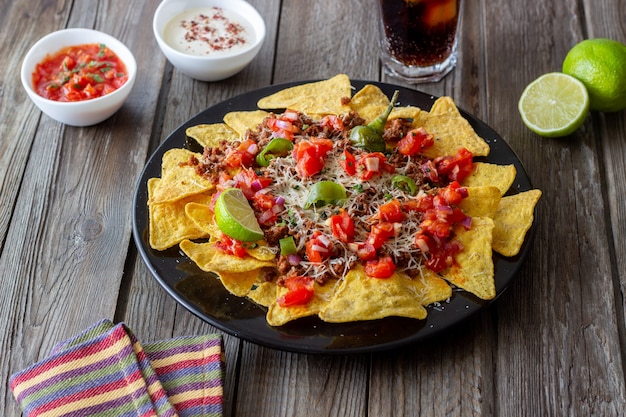 Nachos de chips de maíz con carne, queso, tomates y pimientos. Comida mexicana. Cocina nacional.