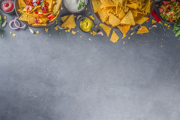 Nachos-Chips mit verschiedenen Dips, traditioneller mexikanischer Snack auf Teller