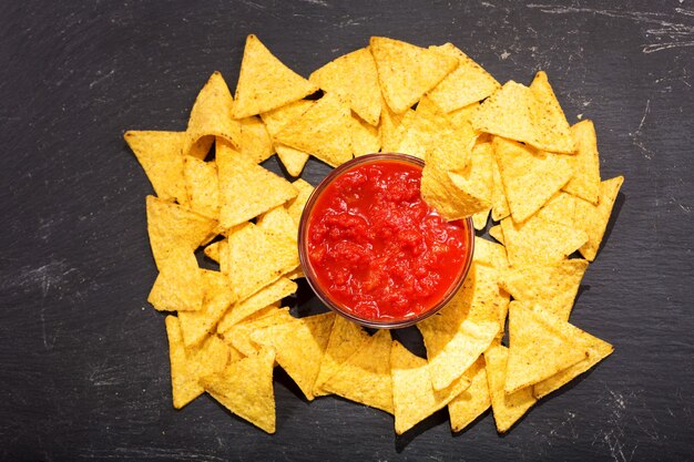 Nachos com molho na mesa escura, vista de cima