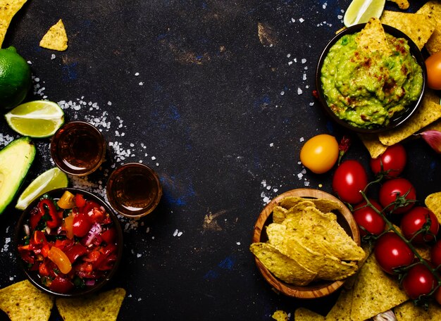 Foto nachos guacamole salsa sauce schwarzer hintergrund draufsicht