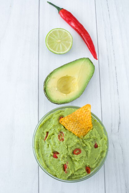 Nachos y guacamole en tazón de madera blanca