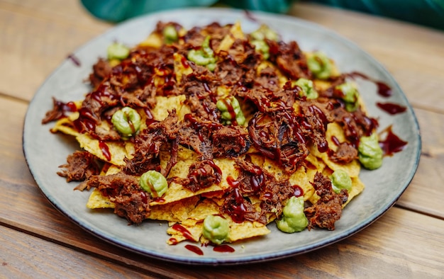 Nachos mexicanos con carne de res y chile en mesa de madera