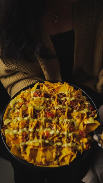 Foto nachos mit gebratenem hackfleisch und guacamole mit käse, tomaten und tauchsauce