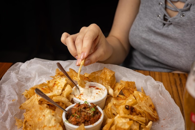 Nachos con salsas en platos sobre una mesa de madera