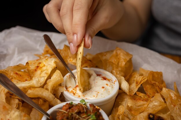 Nachos con salsas en platos sobre una mesa de madera