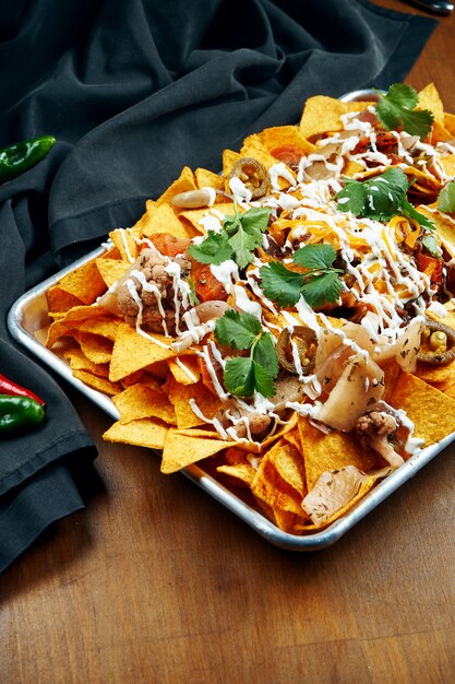 Nachos - um aperitivo mexicano clássico feito com tortilhas de milho. nachos com molhos e holopenya. vista do topo. fechar-se.