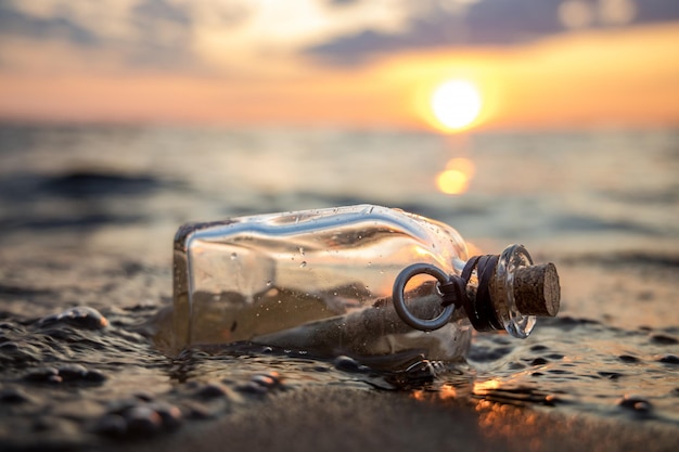 Foto nachricht in der flasche gegen die untergehende sonne