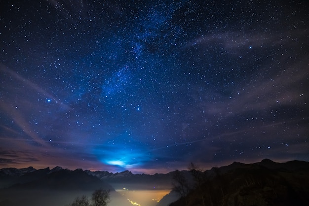 Nacht auf den Alpen unter sternenklarem Himmel- und Mondscheinhintergrund