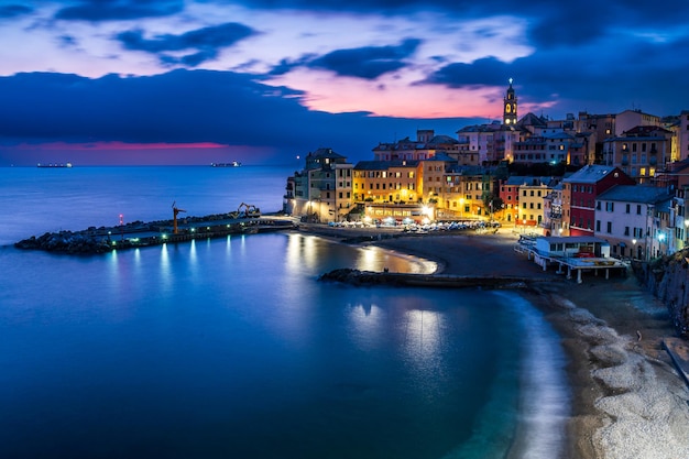 Nachtansicht der Altstadt von Bogliasco, beleuchtet mit Lichtern, die sich auf dem Meer spiegeln