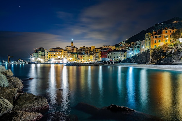 Nachtansicht der Altstadt von Bogliasco, beleuchtet mit Lichtern, die sich auf dem Meer spiegeln