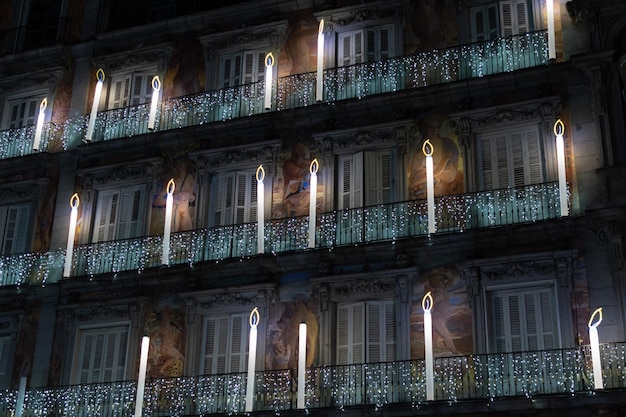 Nachtansicht der Fassade eines Gebäudes mit Weihnachtsschmuck und Kerzen auf der Plaza Mayor in Madrid Spanien