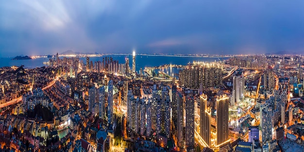 Nachtansicht der Luftaufnahmen von modernen Stadtgebäuden in Qingdao, China