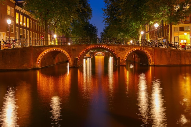 Nachtansicht der Stadt Amsterdam Grachten und sieben Brücken, Holland, Niederlande.