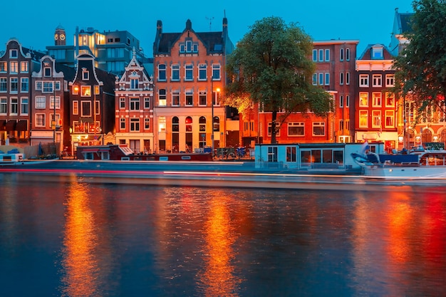 Nachtansicht der Stadt Amsterdam-Kanal, typische holländische Häuser und Boote, Holland, Niederlande.