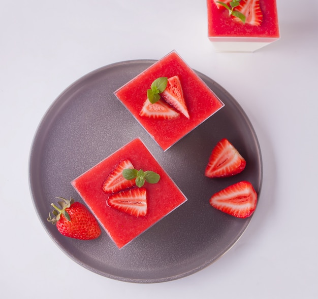 Nachtisch Panna Cotta mit frischen Erdbeeren auf Weiß