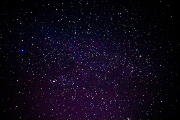 Nachtlandschaft mit bunter und hellgelber Milchstraße voller Sterne am Himmel.