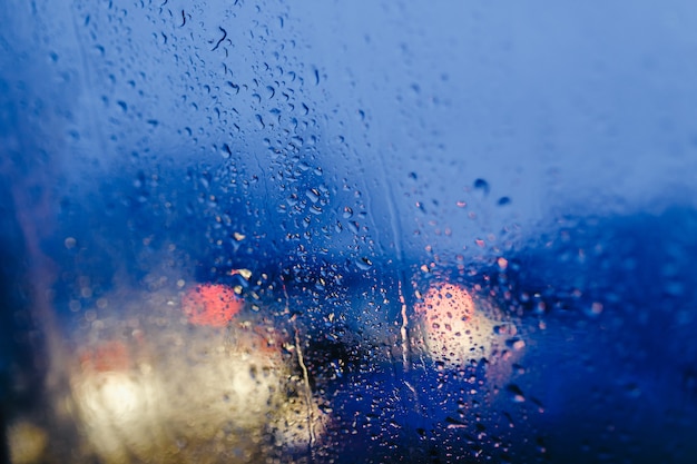 Nachtlichter der Stadt durch Windschutzscheibe abstrakten Hintergrundwassertropfen auf den Glaslichtern und Regen.