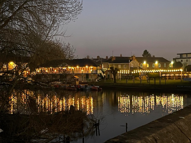 Nachtlichter von Cafés, die sich im Flusswasser in einer Altstadt spiegeln