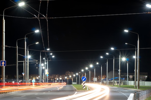 Nachtlichtlinien der Stadt von Autos Autos auf der Autobahn mit Bewegungsunschärfe Straßenansicht der modernen Stadt bei Nacht Viel Licht von Autoscheinwerfern, Werbebannern und Nachtlichtern