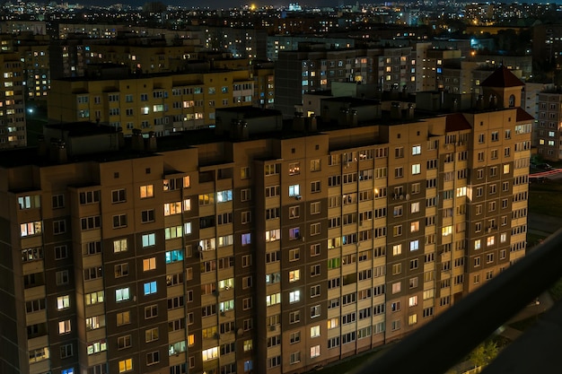 Nachtpanorama von Licht in den Fenstern eines mehrstöckigen Gebäudelebens in einer Großstadt