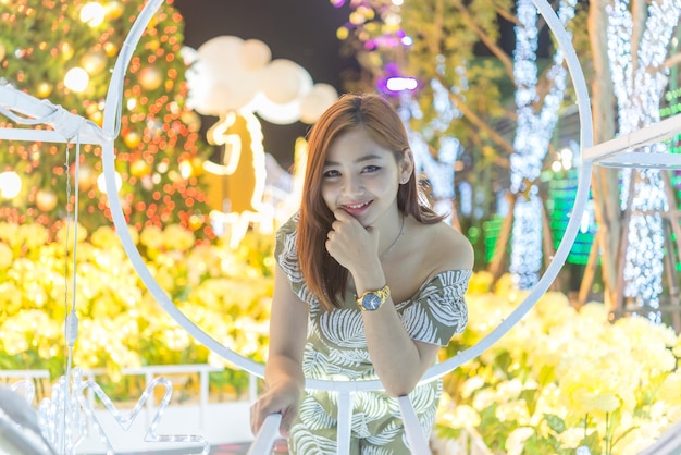 Nachtporträt der schönen asiatischen Frau Thailand-Mädchen posieren, um nachts ein Foto auf Bokeh-Licht zu machen