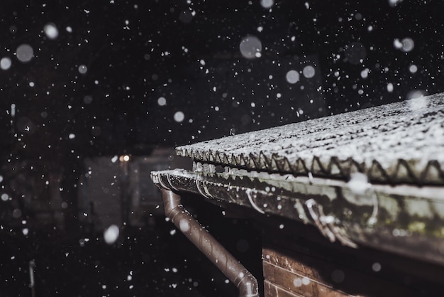 Nachtschneefall über dem Dach des Hauses Winterwetter