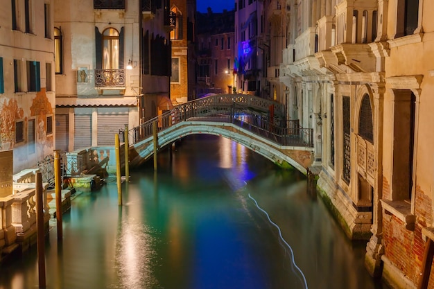 Nachtseitlicher Kanal und Brücke in Venedig Italien