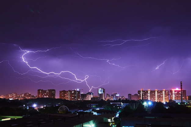 Nachtstadt mit hellen Blitzen in einem stürmischen Himmel
