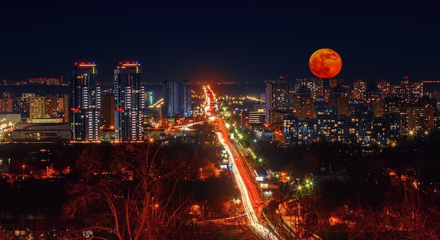 Nachtstadt mit rotem Vollmond