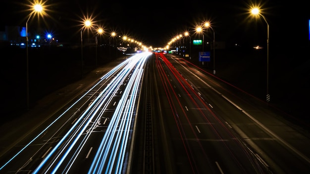 Nachtverkehrsautolichter auf einer großen Straßenansicht von oben weißen und roten Lichtlinien