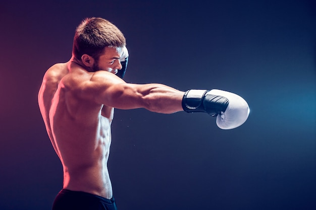 Nackter Oberkörper Boxer mit Handschuhen auf dunklem Hintergrund. Isolieren