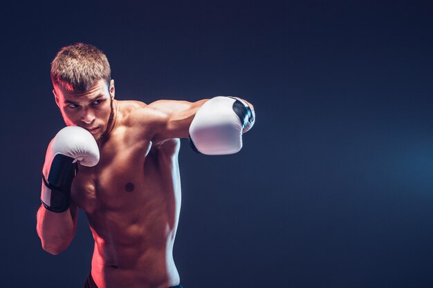 Nackter Oberkörper Boxer mit Handschuhen auf dunklem Hintergrund. Isolieren