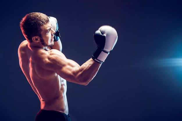 Nackter Oberkörper Boxer mit Handschuhen auf dunklem Hintergrund. Isolieren