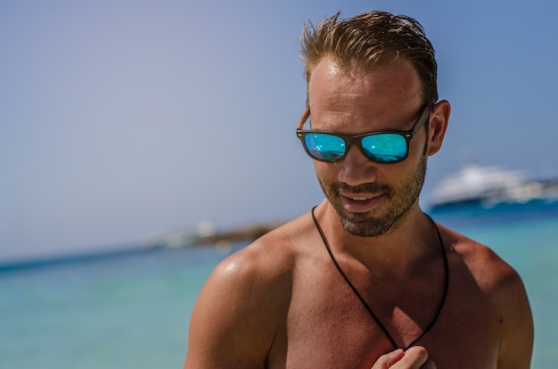 Nackter Oberkörper Mann, der den Strand genießt