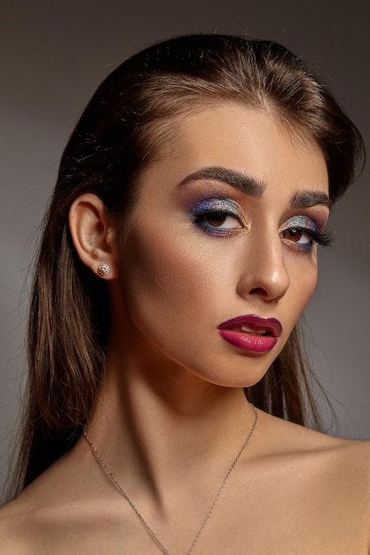 Foto nacktes mädchen in halskette und ohrringen posiert auf grauem hintergrund luxus-make-up perfekte haut bunte augen ...