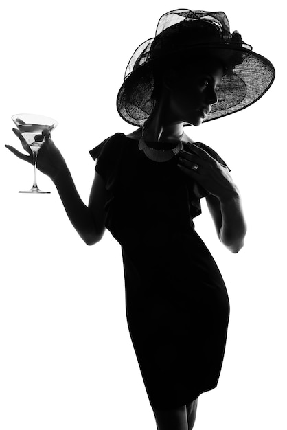 Nada dice clase como una copa de martini. Foto de estudio de una mujer con estilo en silueta bebiendo un martini contra un fondo blanco.