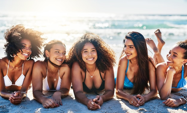Nada inspira felicidad como un día de playa con las mejores amigas Retrato de un grupo de mujeres jóvenes felices relajándose juntas en la playa
