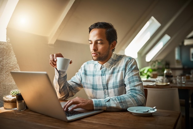 Nada va de la mano como Internet gratis y un buen café Foto de un joven empresario usando su computadora portátil en una cafetería