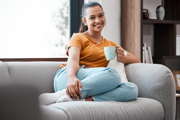 Nada mejor que una taza de café caliente Foto de una mujer joven relajándose en el sofá de su casa