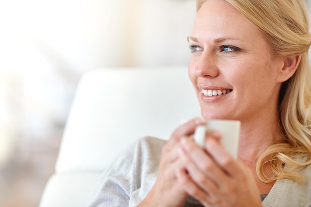 Nada mejor que una taza de café recién hecho Foto de una mujer disfrutando de una taza de café en casa