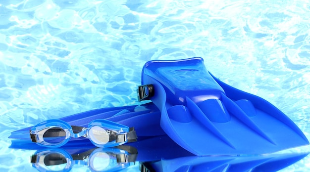 Nadadeiras azuis e óculos de proteção no fundo do mar azul