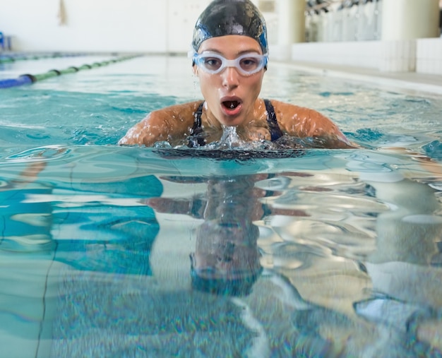 Nadador aptos que sube para tomar el aire en la piscina