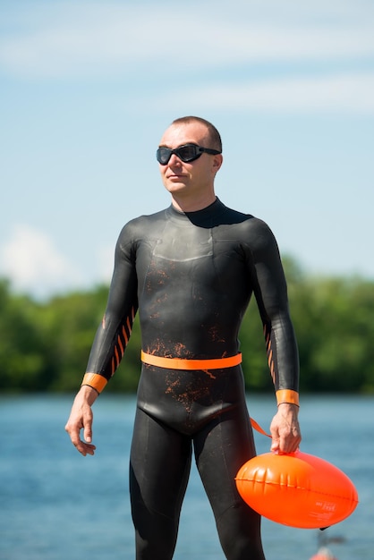 Foto nadador atleta en traje de neopreno con una boya con gafas protectoras