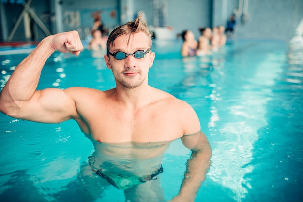 Nadador atlético mostra músculos, esportes aquáticos