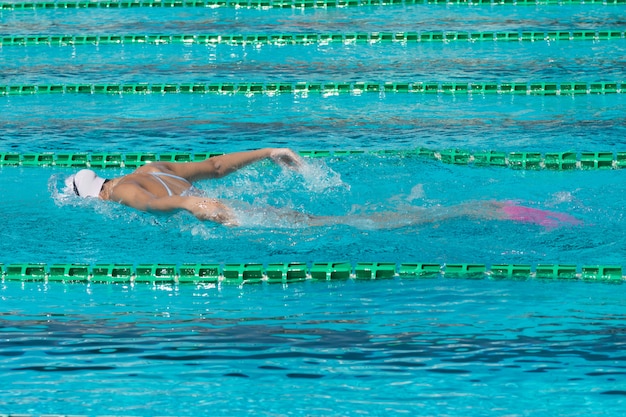 Nadador en piscina de carril, mujer en agua.