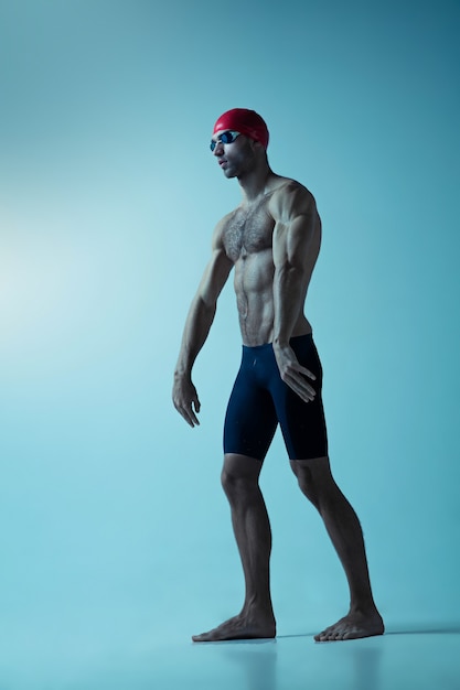 Nadador profesional masculino con sombrero y gafas en movimiento y acción