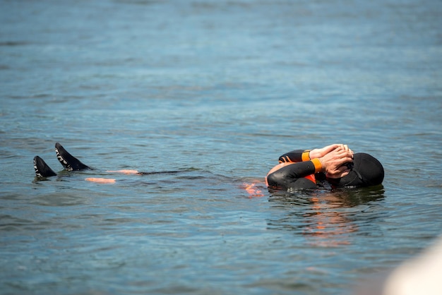 Un nadador en traje de neopreno se encuentra en el agua del río.