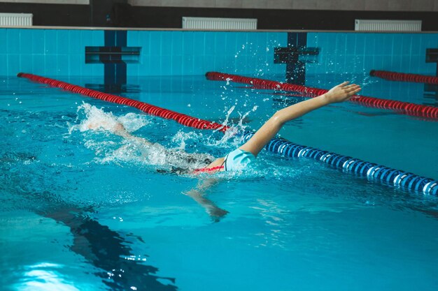 Nadadora compitiendo en la piscina Una atleta profesional supera el estrés y la adversidad en la piscina