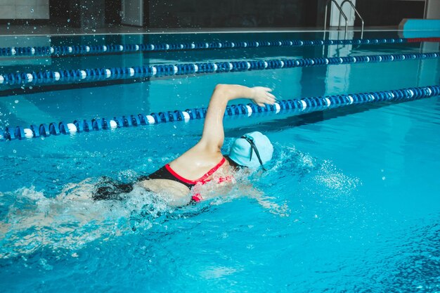 Nadadora compitiendo en la piscina Una atleta profesional supera el estrés y la adversidad en la piscina