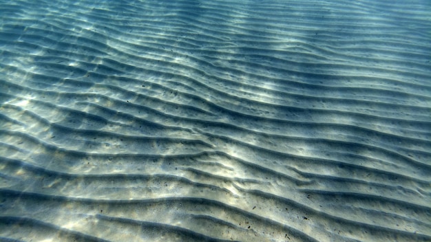 Nadar bajo el agua con fondo de arena en una laguna turquesa